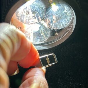 Silver ring with a silver lightning bolt in the center against a black backgrnd